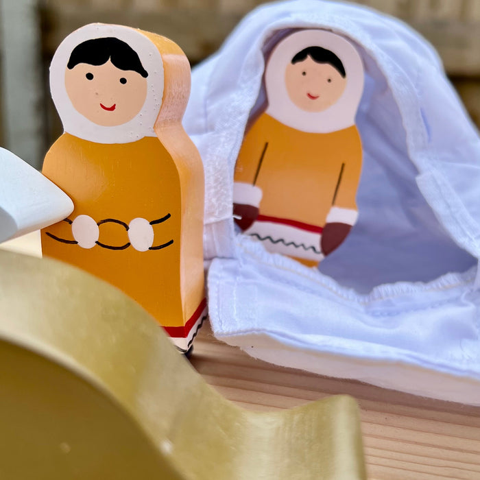Wooden dolls with traditional attire on a wooden surface