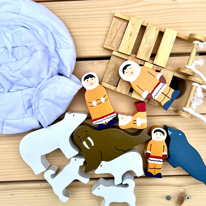 Wooden toys on a wooden surface including animals and figures.